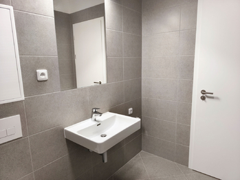 Koupelna s vanou, umyvadlem, toaletou a topným žebříkem. - Pronájem bytu 2+kk v družstevním vlastnictví 50 m², Praha 9 - Vysočany