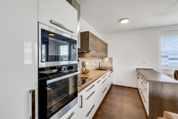 Obývací pokoj - kuchyňská linka - Prodej bytu 4+kk v osobním vlastnictví 107 m², Praha 10 - Dolní Měcholupy