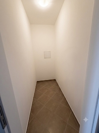 Zděná místnsot v předsíni využívaná jako úklidová místnost nebo šatna. - Prodej bytu 2+kk v osobním vlastnictví 61 m², Praha 9 - Letňany