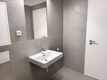 Koupelna s vanou, umyvadlem, toaletou a topným žebříkem. - Pronájem bytu 2+kk v družstevním vlastnictví 50 m², Praha 9 - Vysočany