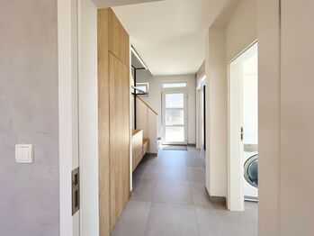 V přízemí najdete hobby místnost, nenápadnou šatnu pod schodištěm, koupelnu se sprchovým koutem a toaletou - Prodej domu 125 m², Nehvizdy