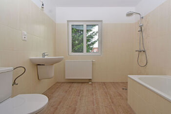 Koupelna s vanou, sprchovým koutem, toaletou a umyvadlem.  - Prodej domu 100 m², Vlastislav
