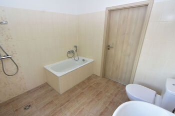Koupelna s vanou, sprchovým koutem, toaletou a umyvadlem.  - Prodej domu 100 m², Vlastislav