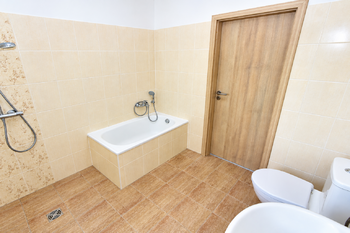 Koupelna s vanou, sprchovým koutem, toaletou a umyvadlem.  - Prodej domu 100 m², Vlastislav