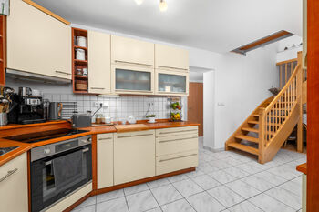 kuchyně se schodištěm - Prodej domu 137 m², Lišov